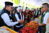 Gubernur Jawa Timur Khofifah Indar Parawansa didampingi Bupati KH. Kholilurrahman memantau aktifitas jual beli dalam kegiatan pasar murah di Pamekasan. (Foto Istimewa)